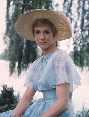 a woman in a blue dress and straw hat