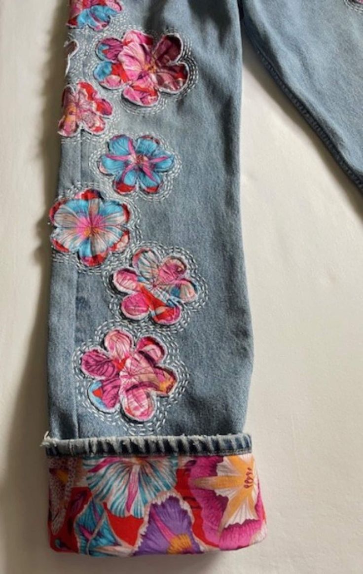 an old pair of jeans with flowers on them