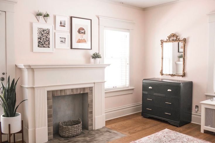 a living room with a fire place and pictures on the wall