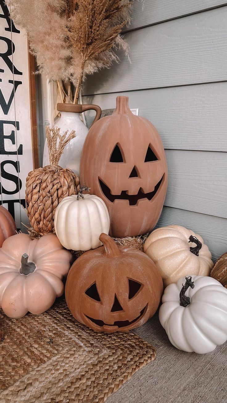 pumpkins and gourds are sitting on the front porch for halloween decorating