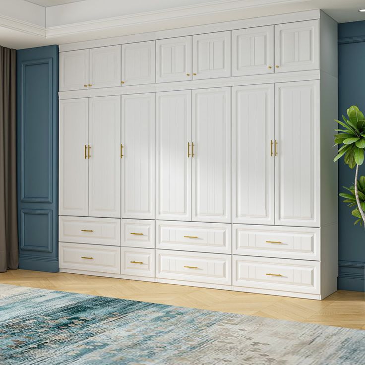 a living room with blue walls and white cupboards in the corner, along with a rug on the floor