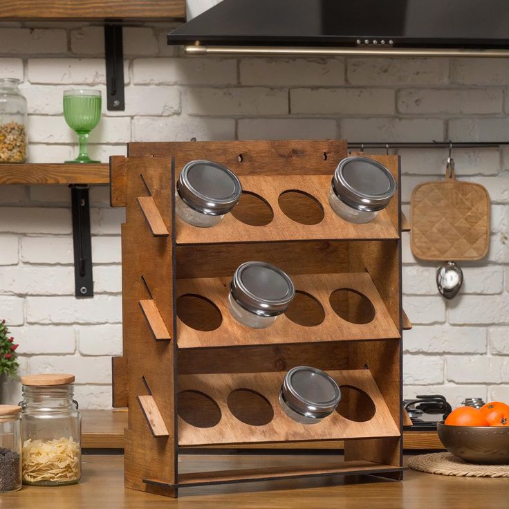 a wooden spice rack with pots and pans on it in the middle of a kitchen