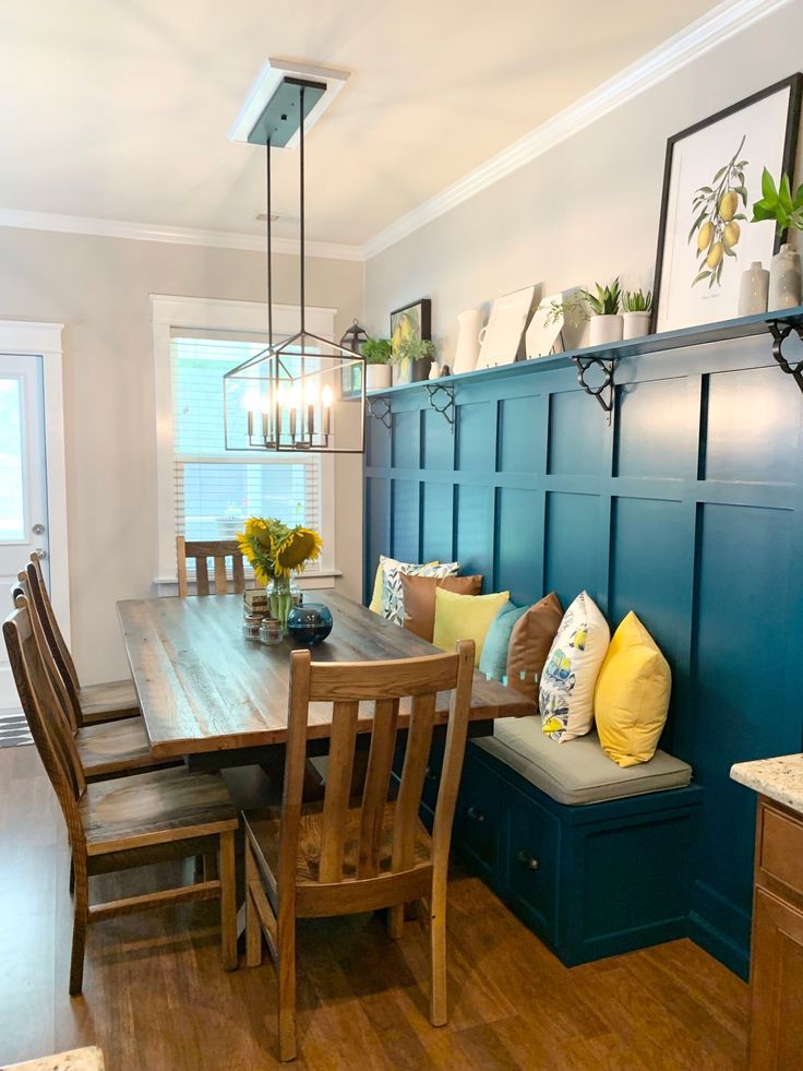 a dinning room table and bench in a kitchen with blue walls, wood floors and hardwood flooring