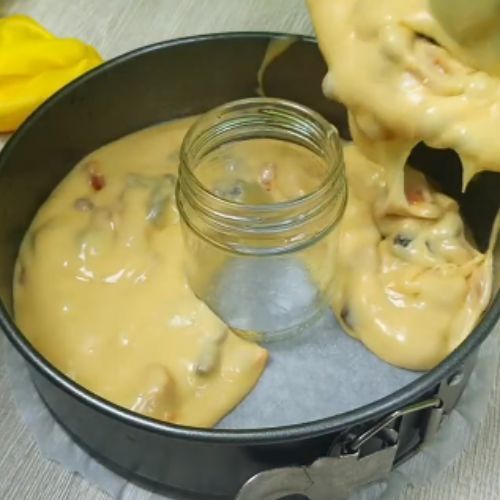 a pan filled with cheese sauce next to a jar