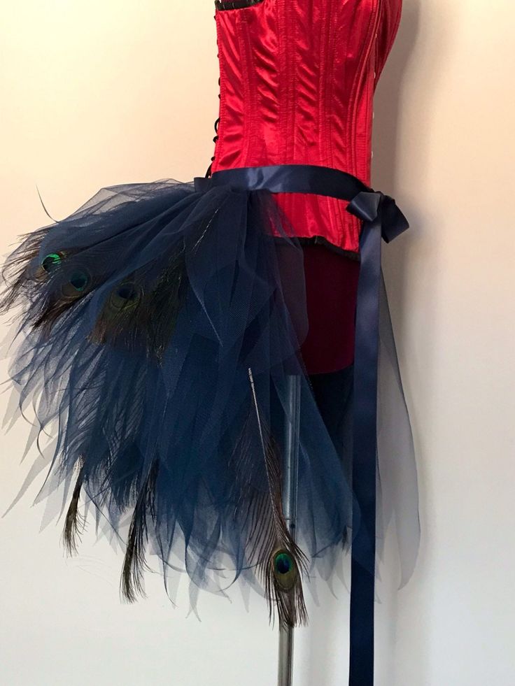 a mannequin wearing a red top and blue feather skirt