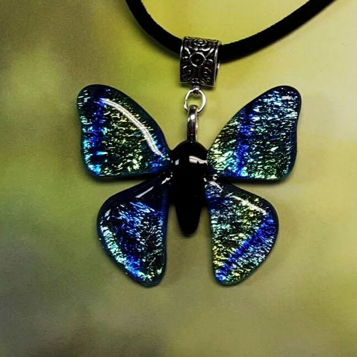 a blue and black butterfly pendant on a leather cord