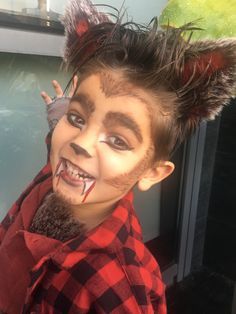 a young boy with his hair in the shape of a wolf is smiling at the camera