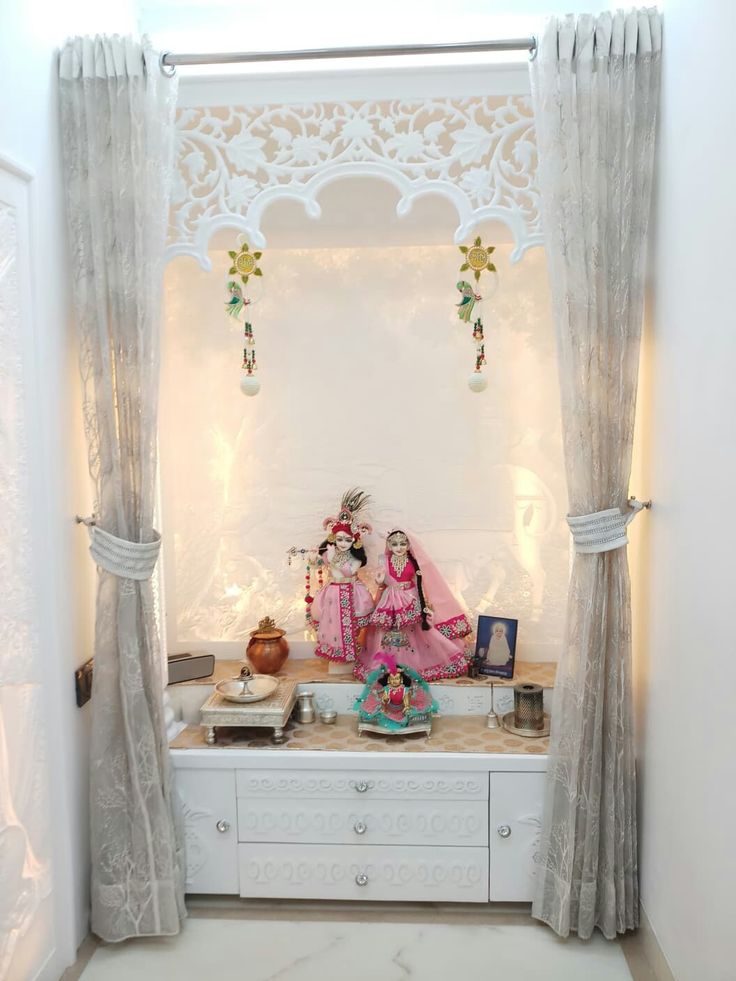 a woman sitting on top of a white bench in front of a window with curtains