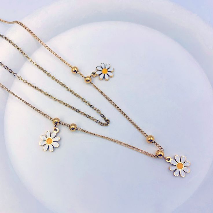 Get ready to bloom with our Chrysanthemum Layered Necklace! e flower details add a playful and youthful flair to your look, while the layered design adds depth and dimension. Featuring three adorable flower charms on the larger chain, this necklace is the perfect way to add freshness and charm to any outfit. Charming Flower Pendant Necklace, Trendy Flower Necklace As A Gift, Trendy Flower Necklace For Gifts, Charming Gold Flower Necklace, Trendy Flower Necklace With Flower Charm Pendant, Trendy Flower Pendant Necklace With Charm, Trendy Flower Necklace With Flower Pendant, Adjustable Flower Shaped Necklace For Spring, Trendy Flower Shaped Necklace As Gift