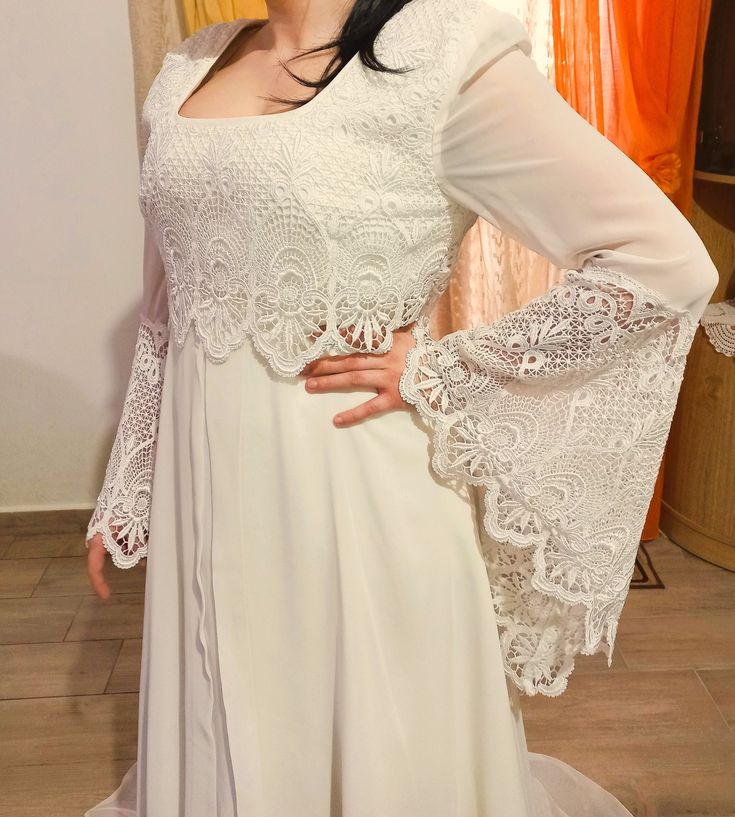 a woman in a white wedding dress posing for the camera with her hands on her hips