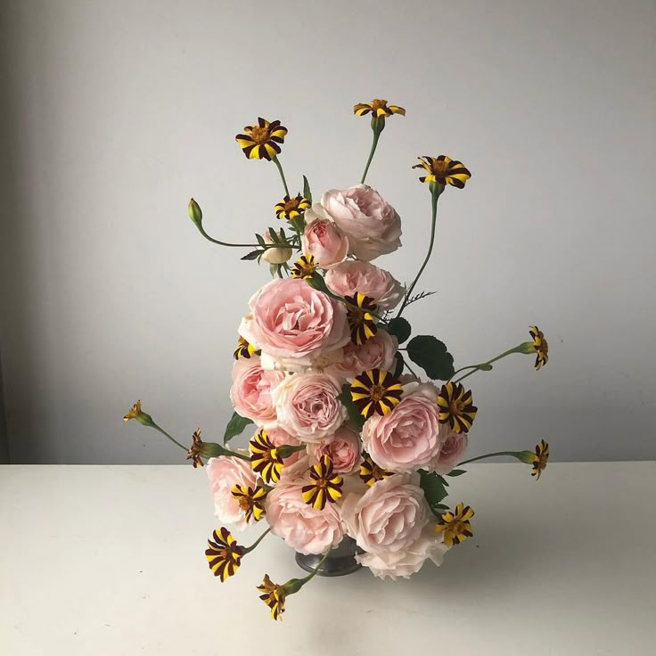 a vase filled with pink and yellow flowers