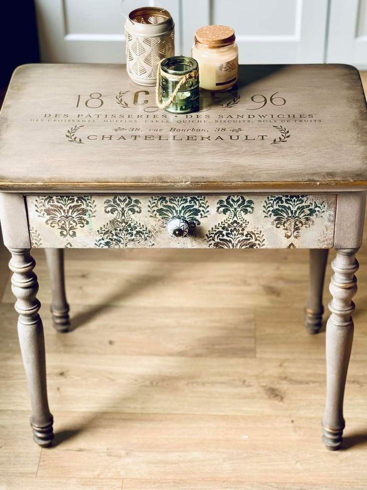 a small table with some jars on it and a candle sitting on top of it