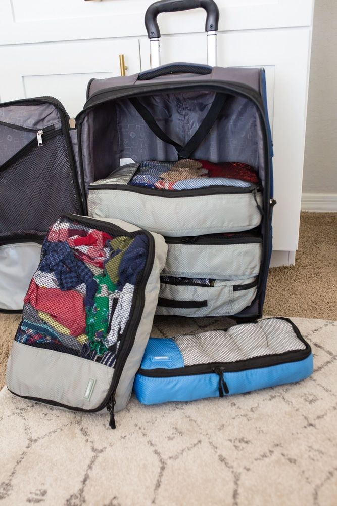 three pieces of luggage sitting on the floor in front of a white cabinet and door