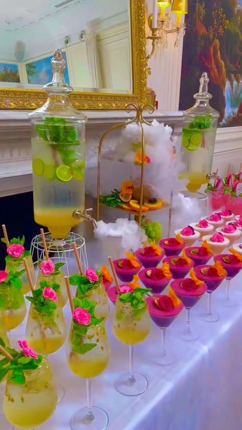 a table topped with glasses filled with drinks and desserts on top of each other