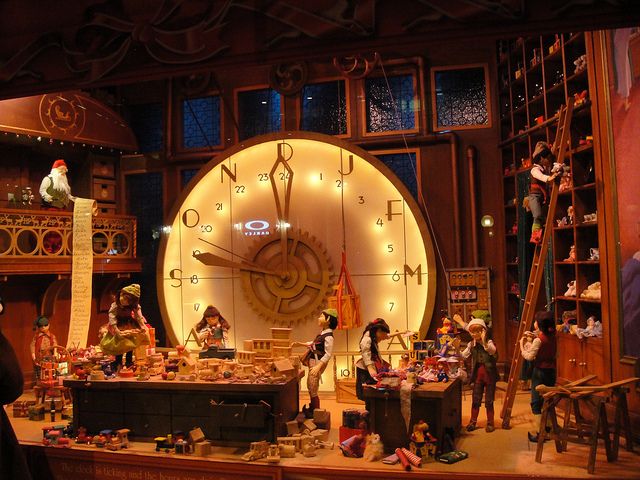 a large clock in the middle of a room filled with figurines and toys