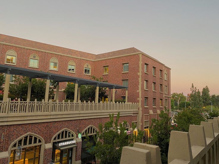 an outside view of a brick building with many windows and balconies on the roof