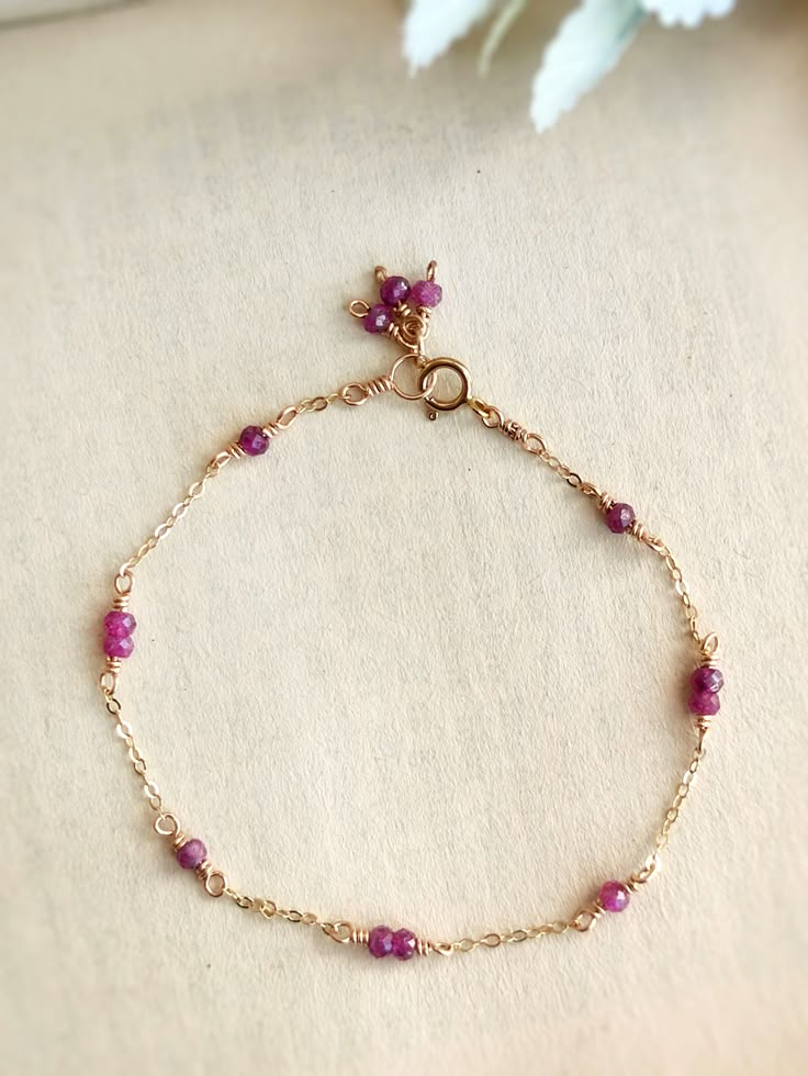 This dainty bracelet is handmade with tiny genuine ruby beads in 14K Gold Filled, Rose Gold Filled, or Sterling Silver. It is hypoallergenic and nickel-free.The delicate chain is made with a 1-2-1 stone pattern and ends with a cute cluster of 3 stones for decoration.• Gemstone size: 2-3 mm• Made with natural, genuine ruby beads📏 To find your bracelet size, measure your wrist and add 0.5 - 1 inch for room to wiggle, depending on your personal preference. For example, if your wrist is 6 inches, y Pearl Bracelet Dainty, Dainty Handmade Jewelry, Stone Bracelet Ideas, Rose Gold Bracelets, Dainty Accessories, Rainbow Moonstone Jewelry, Dainty Gold Bracelet, Beads Craft Jewelry, Stone Accessories