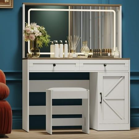 a white dressing table with a mirror and stool next to it in a blue room