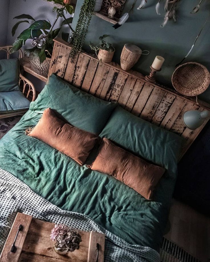 a bed with pillows and blankets on top of it, next to a wooden headboard