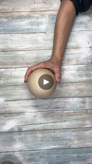 a person holding a ball on top of a wooden floor