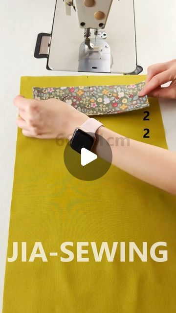 a woman is using a sewing machine to sew something on a yellow table cloth