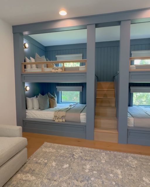 a room with bunk beds and couches in it