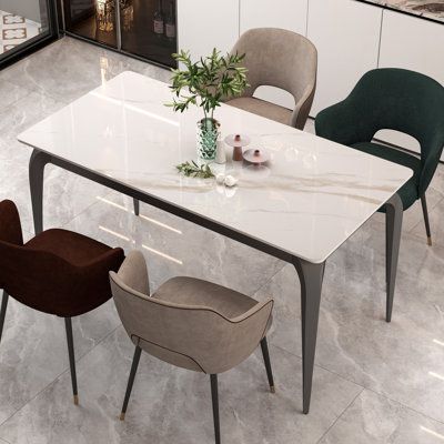 a dining table with chairs around it in a room that has white tile flooring