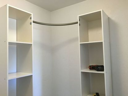 an empty bathroom with white shelving in it