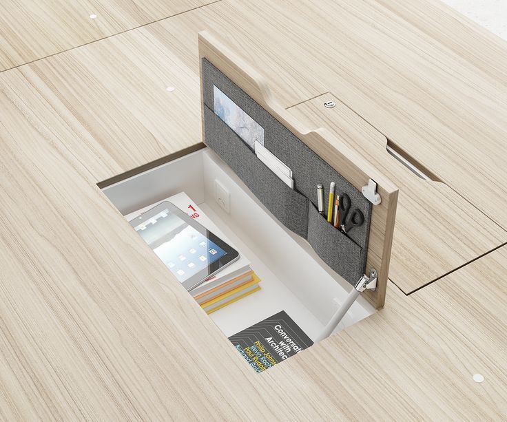 an open drawer on the floor with some books and pens in it, next to a pair of scissors