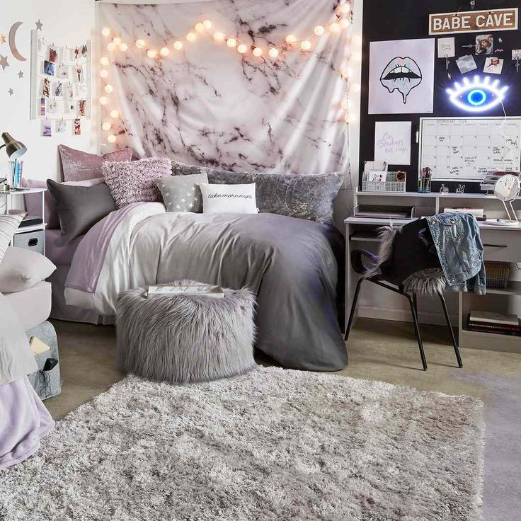 a bed room with a neatly made bed and lights on the headboard above it