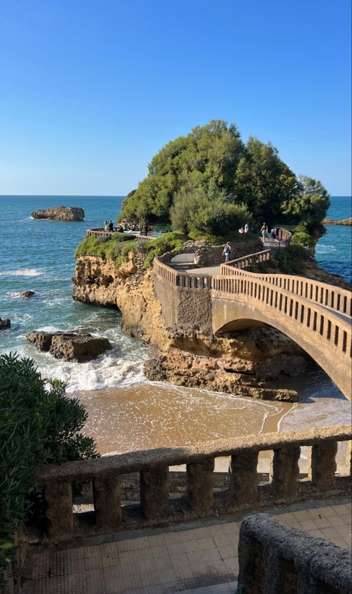 a bridge over the ocean with people walking on it