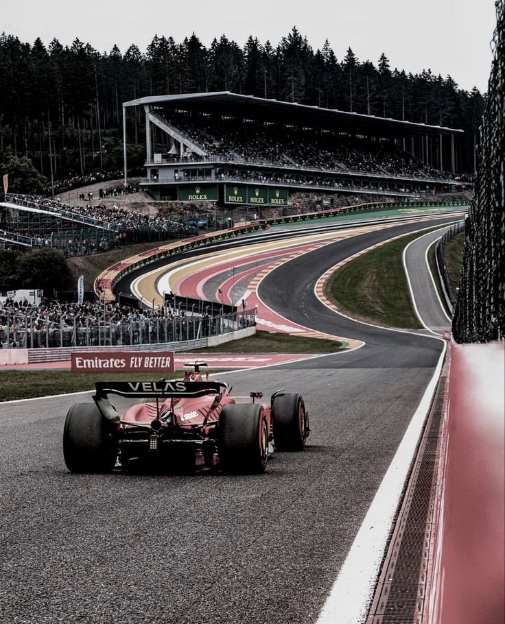 a man driving a red race car down a track