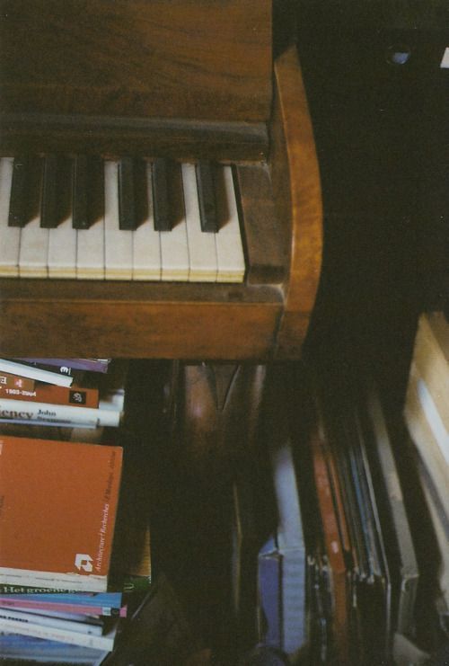 there is a piano and many books on the floor