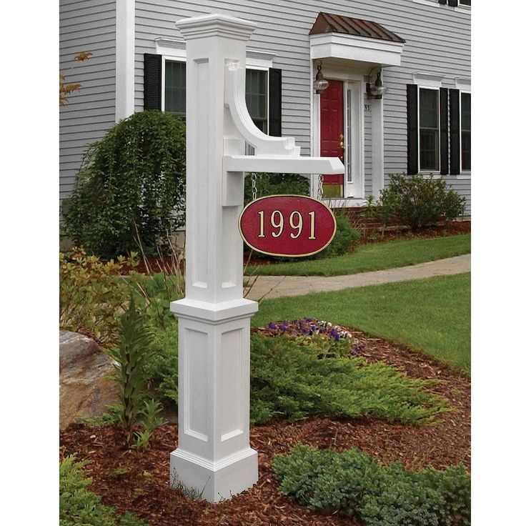 a white mailbox with a red sign in front of a house