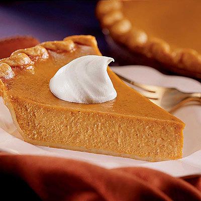 there is a slice of pumpkin pie with whipped cream on top and the rest of it