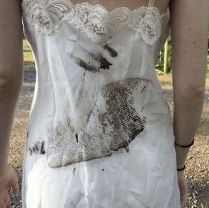 a woman with her back to the camera, wearing a white dress that has an image of a hand on it