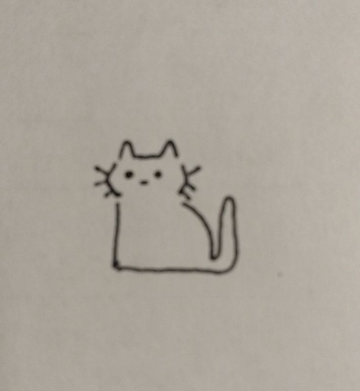 a drawing of a cat sitting on top of a piece of paper