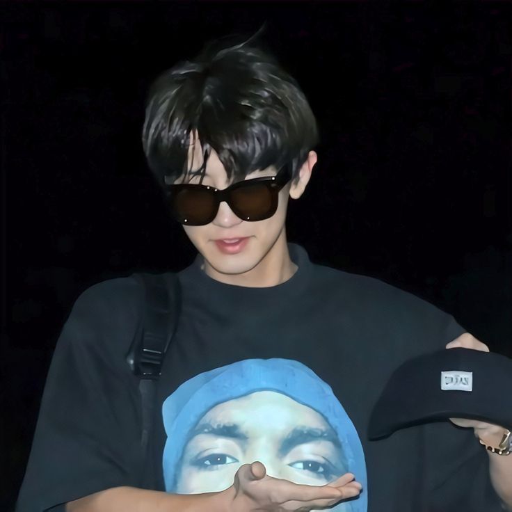 a young man wearing sunglasses and a black t - shirt