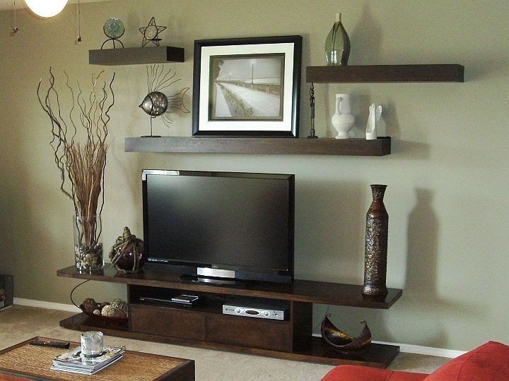 a living room filled with furniture and a flat screen tv on top of a wooden shelf