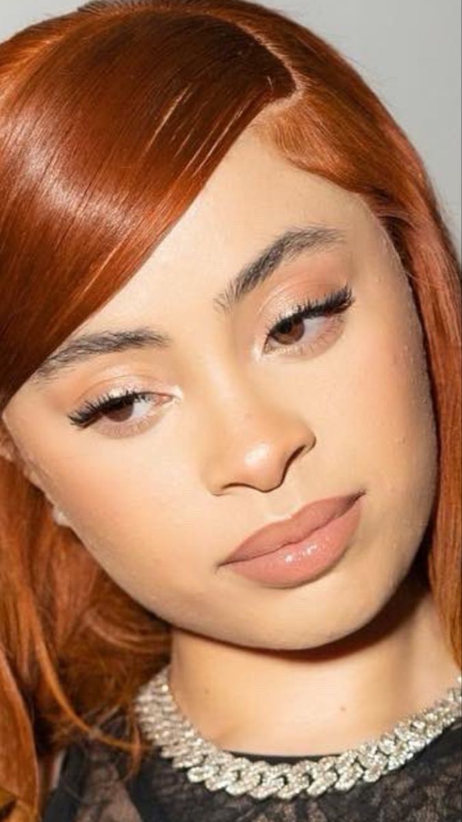 a woman with red hair wearing a black dress and pearls around her neck is looking at the camera