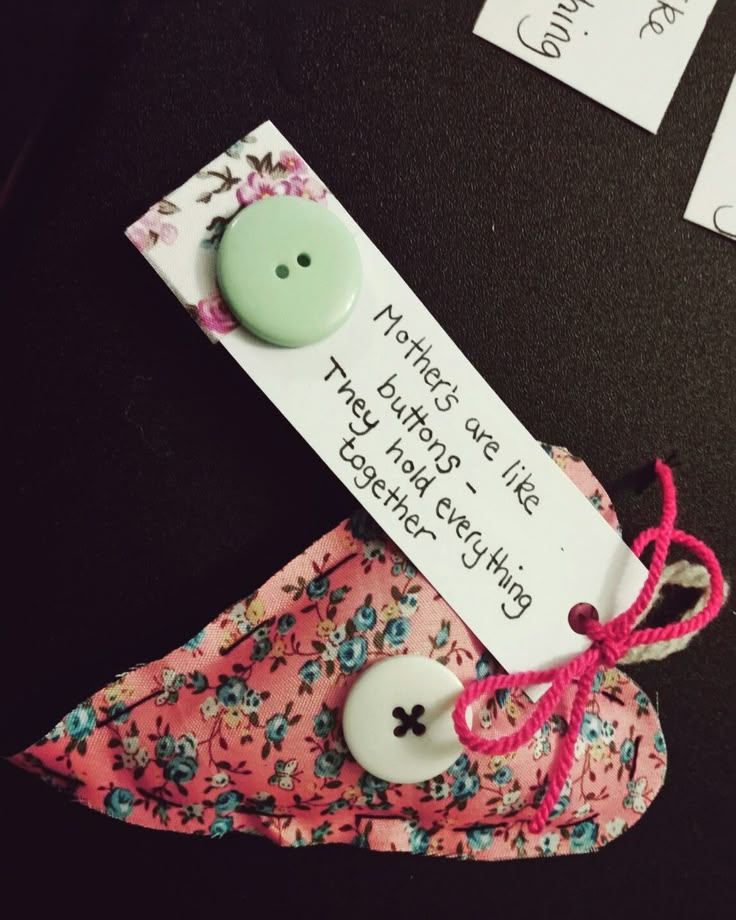 a pink flowered cloth with a button attached to it and some tags on the back