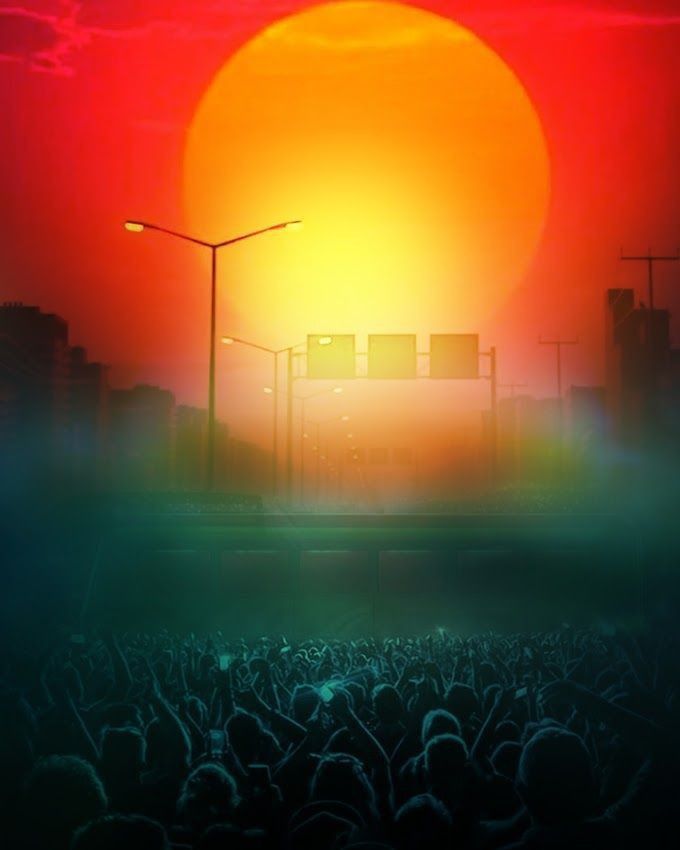 the sun is setting over a large group of people in front of a street light