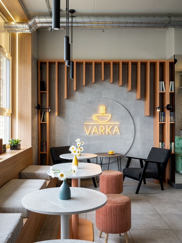 the interior of a restaurant with tables, chairs and stools in front of a sign that reads varka