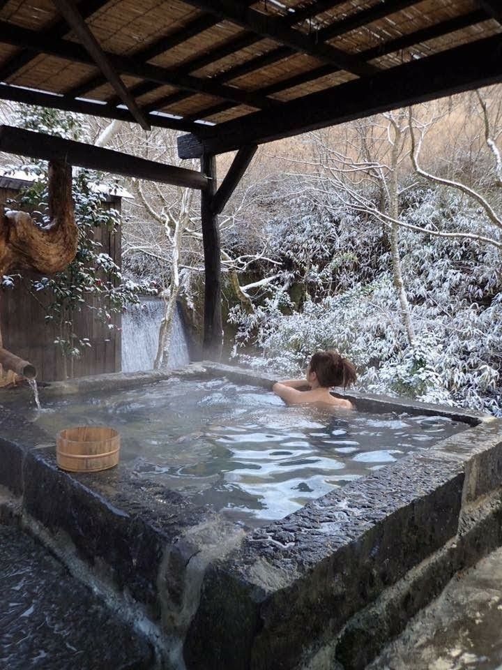 two people in a hot tub with snow on the ground