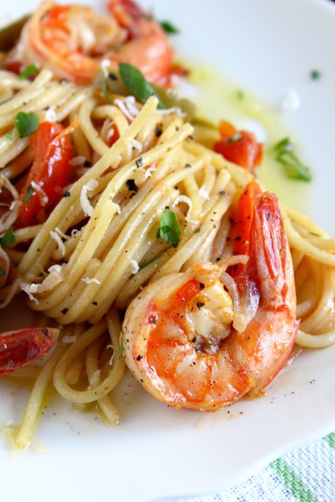 a white plate topped with pasta and shrimp