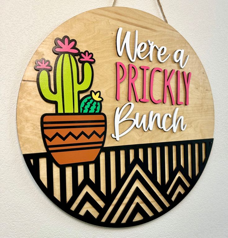 a wooden sign that says, we're a pricky bunch with a cactus in a pot