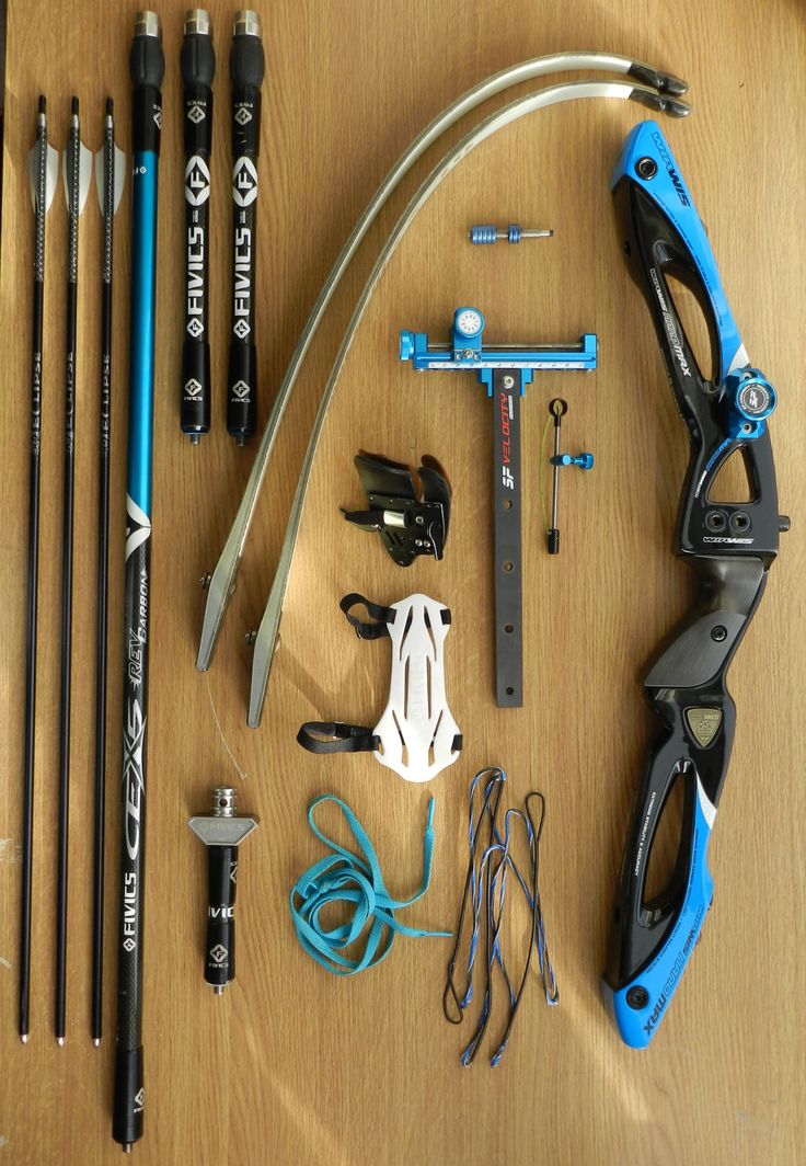 an assortment of tools and accessories laid out on a wooden table with pencils, scissors, tape measure sticks, markers, and other items