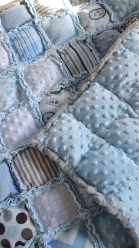 a blue and white quilted blanket on top of a bed with polka dot pillows