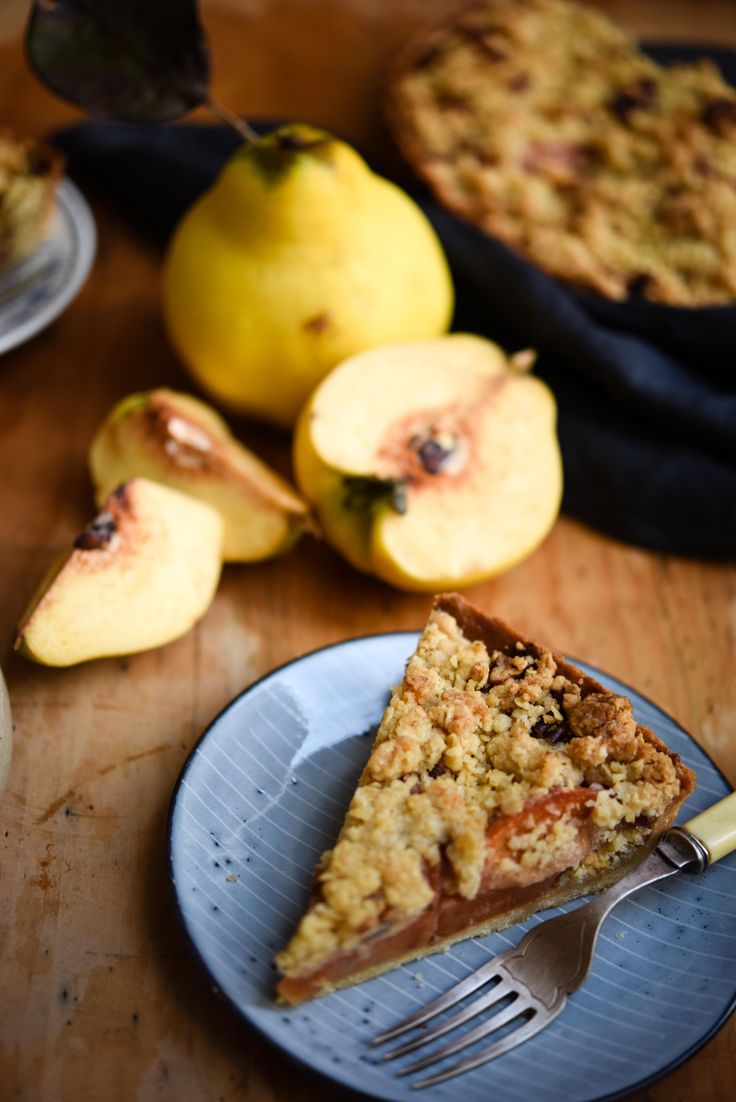 a piece of pie sitting on top of a blue plate next to some sliced apples