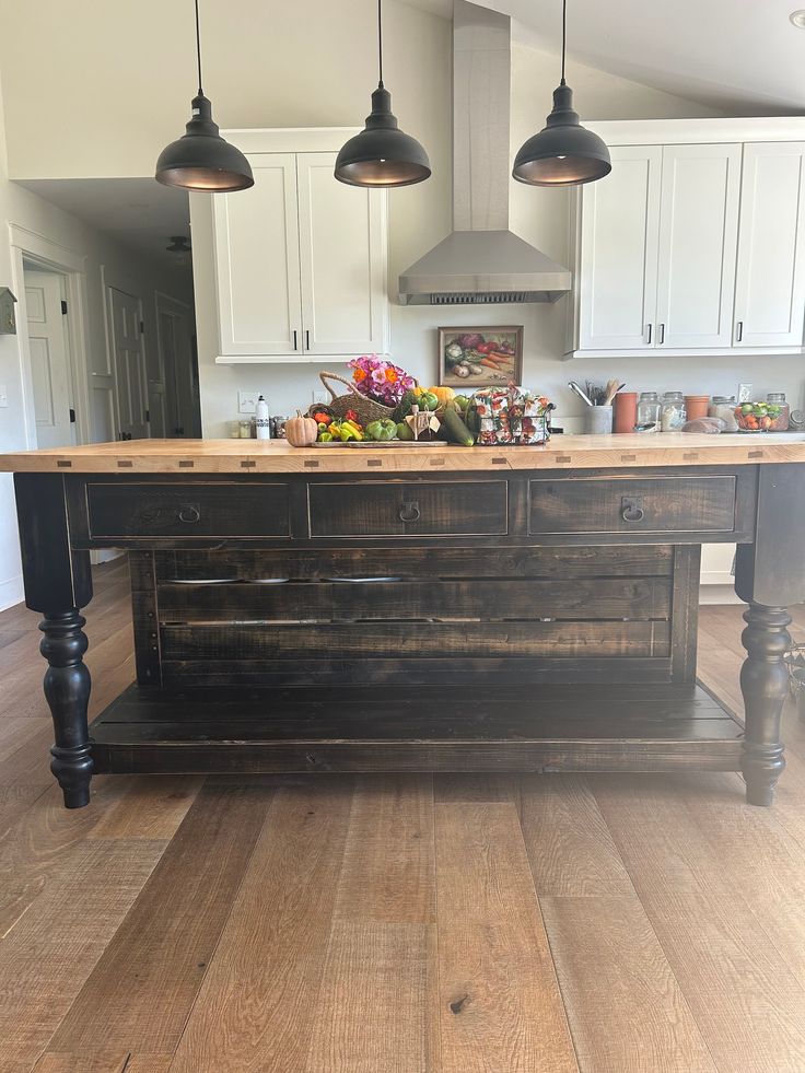 a kitchen island made out of an old pallet wood table with lights hanging over it